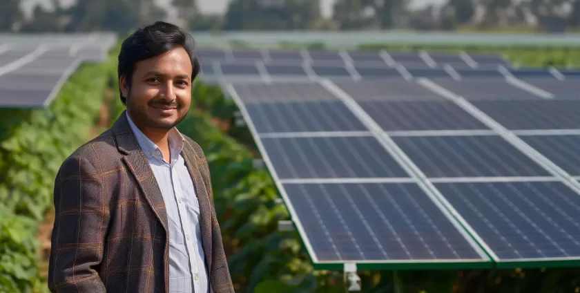Person posing in front of solar panels, promoting sustainability.